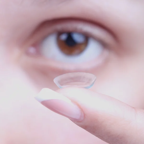 Inserting a contact lens. Close up