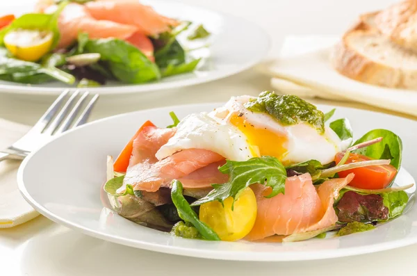 Poached egg salad with smoked salmon, cherry tomatoes and pesto.