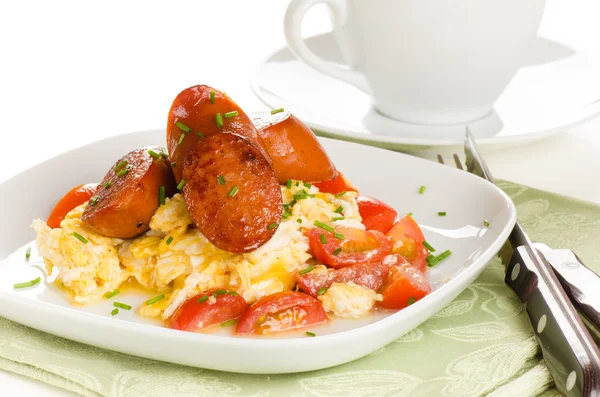 Breakfast of scrambled eggs with tomatoes and chorizo sausage on