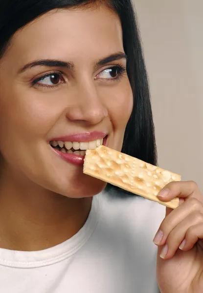 Beautiful young woman eating diet biscuits