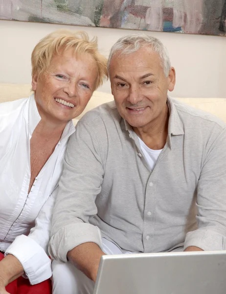 Portrait of a senior couple shopping using computer laptop.