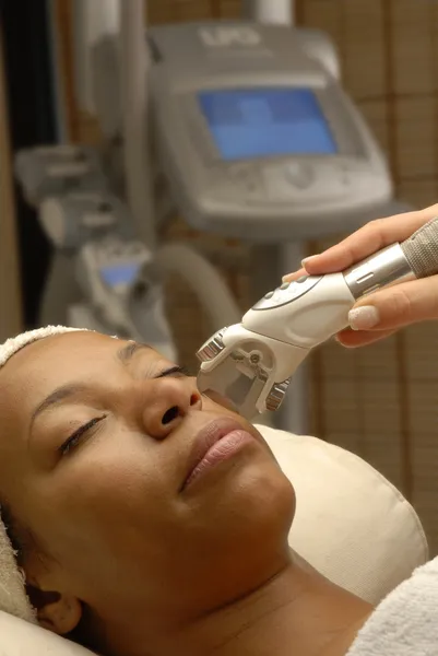 Brunette woman applying facial at a spa laser