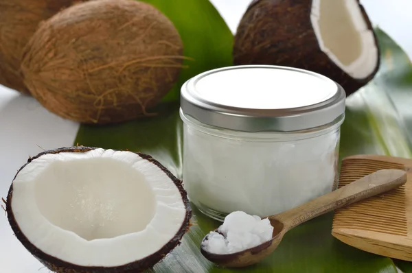 Coconuts and organic coconut oil in a glass jar.