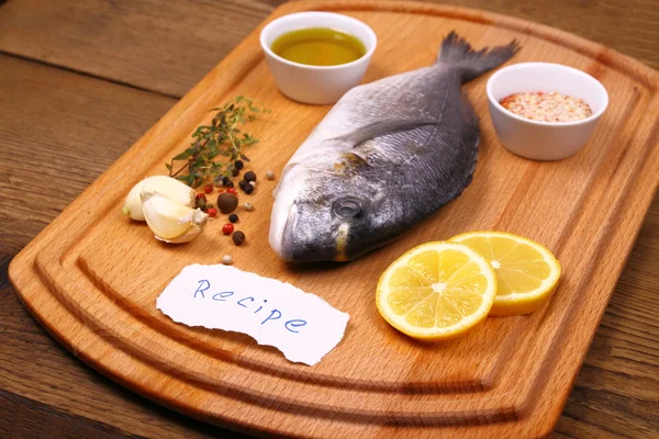 Bream fish on cutting board, ingredients, recipe label
