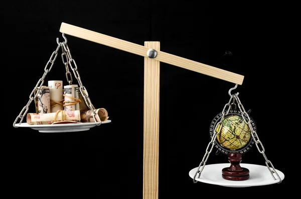 Earth and Money on a Two Pan Balance