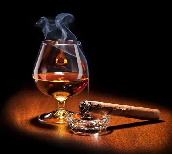 Cognac and Cigar with smoke on black background