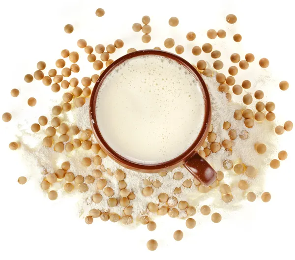 Powdered milk drink in a clay cup with soy beans on white background