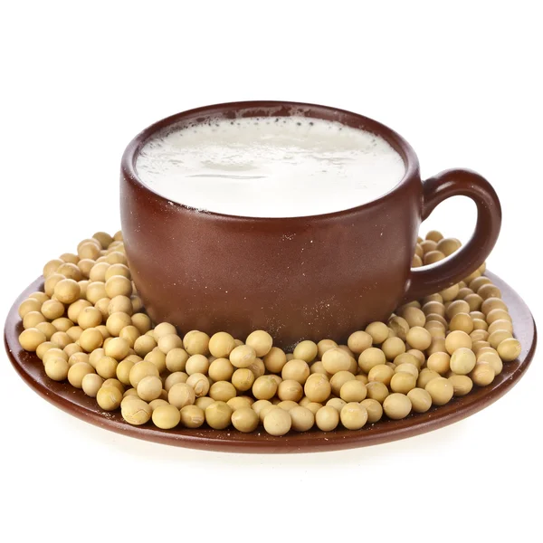 Powdered milk drink in a clay cup with soy beans on white background