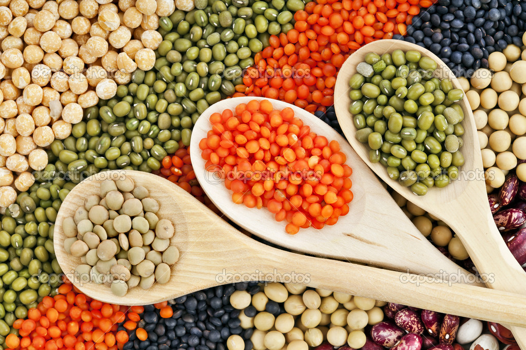 Lentils, beans, peas, soybeans, legumes with spoons textured background — Stock Photo © Madllen