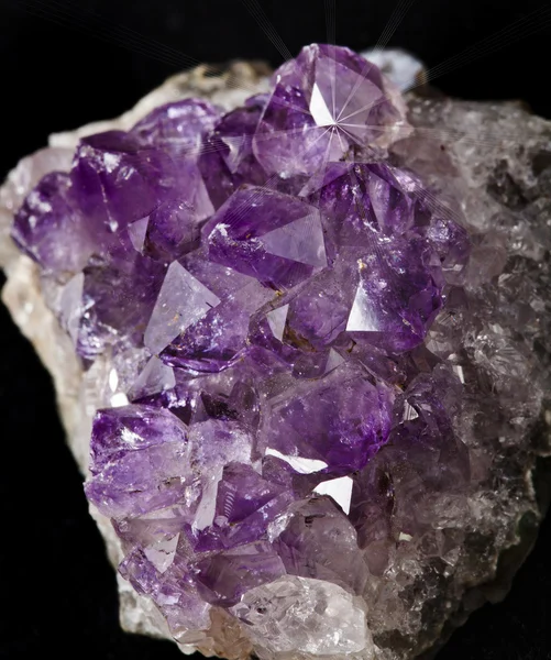 Natural cluster of Amethyst surface close up against a black background