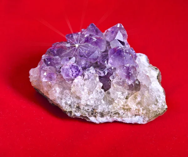 Macro of purple amethyst against a red background -semiprecious gem used for jewels