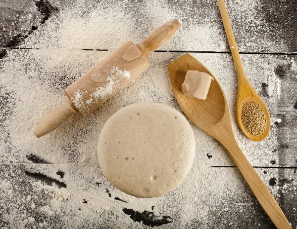 Wooden rolling pin with white wheat flour
