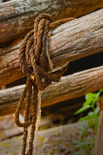 Old rope tied to a piece of old wood.