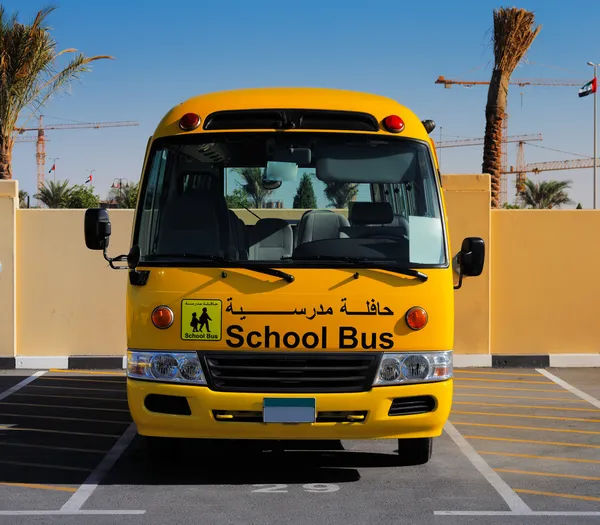 A front on view of a yellow Arabic school bus