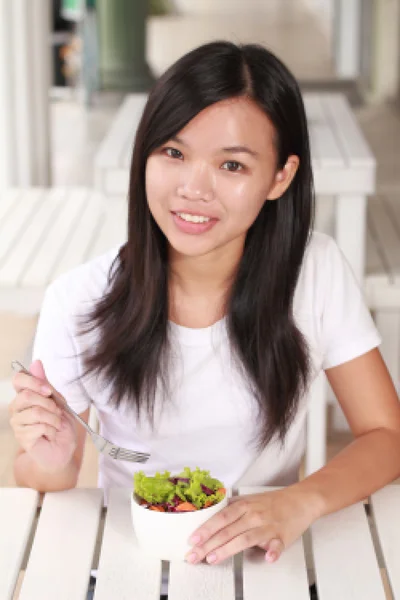 Lady eat vegetable salad on the restaurant