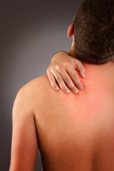 Young male eith neck pain against