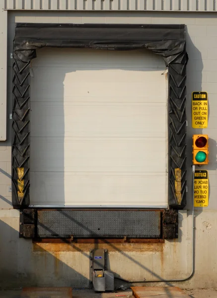 Industrial transport truck loading dock with green light on