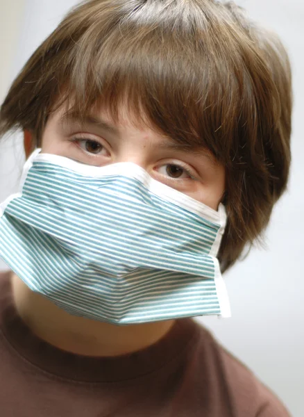 Twelve year old boy with surgical mask on