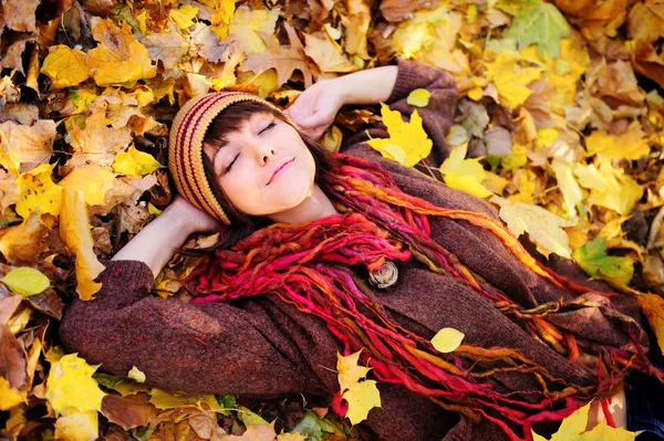 Girl portrait lying in leaves.