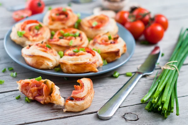 Puff pastry rolls with ham and chese. Baked snacks