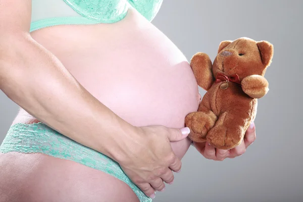 Pregnant girl with a toy bear