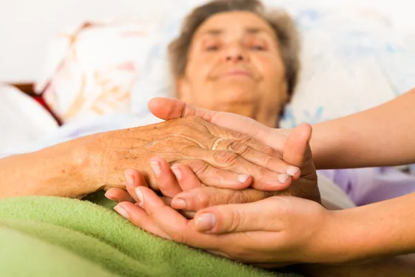 Caring nurse holding hands