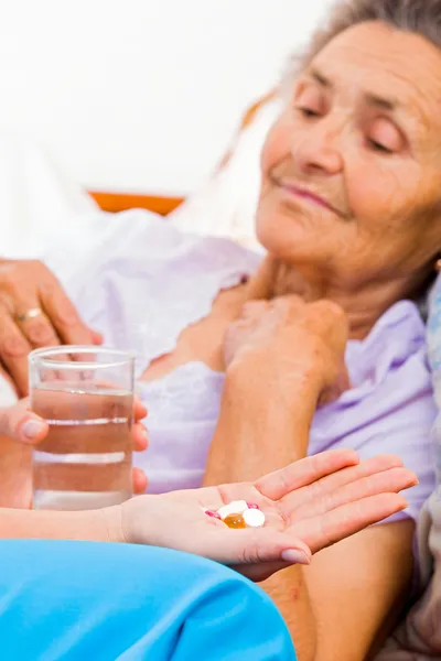 Elderly lady taking pills