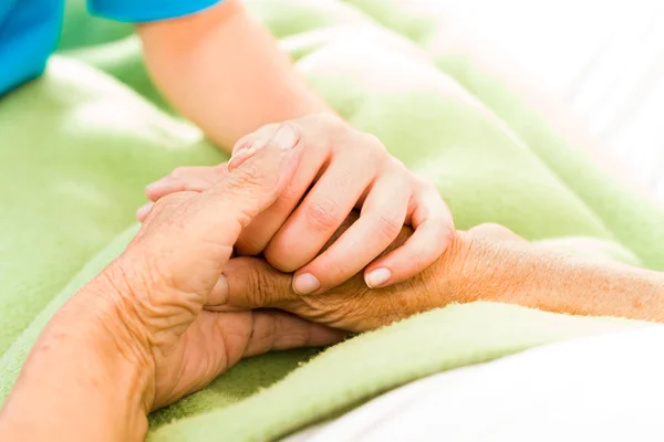 Nurse holding patient hands