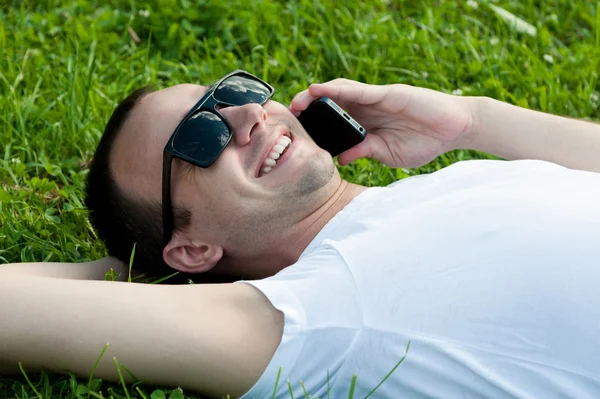 Smiling young guy speaking on mobile phone