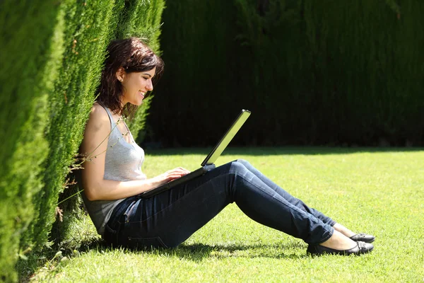 Attractive woman happy in a park with a laptop