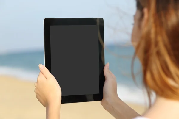 Close up of a woman showing a blank tablet screen on the beach
