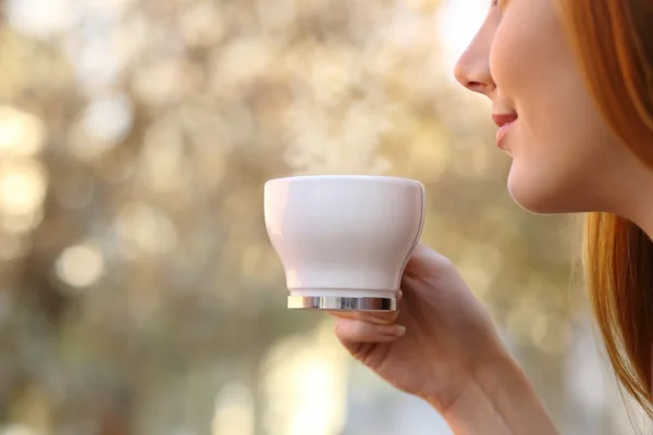 Close up of a woman holding a coffee cup