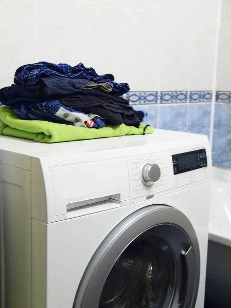 Stack of clothes on top of front-loading washing machine