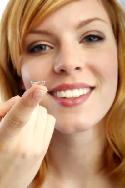 Girl holds finger on a contact lens