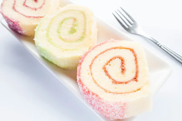 Set of colorful jam roll cakes with fork