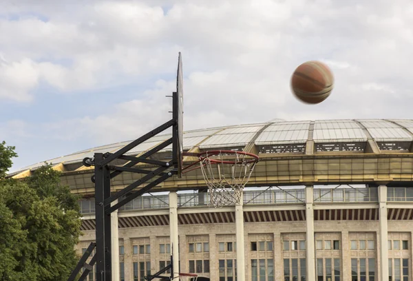 Basketball. The ball flies into the ring against the background