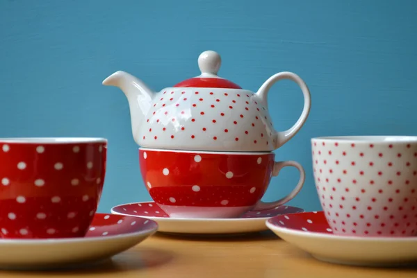 Red polka dots kettle with two cup of tea