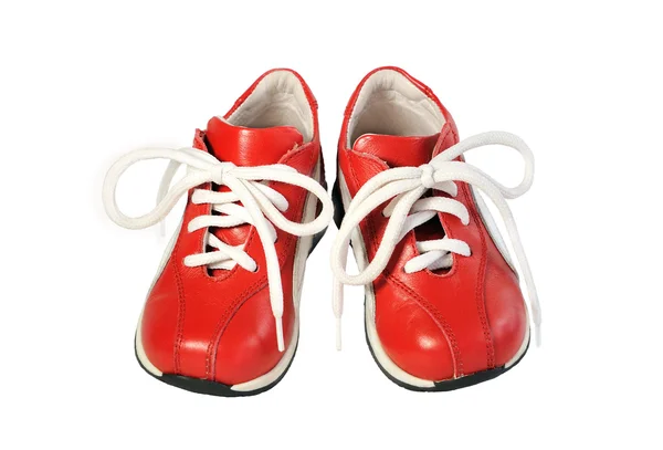 Pair of children's shoes on the red cord on a white background.