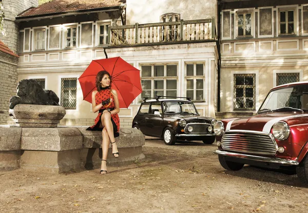 Vintage image of young attractive girl with two old cars