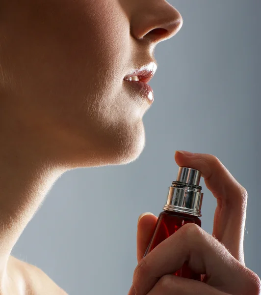 Young attractive woman with the bottle of perfume