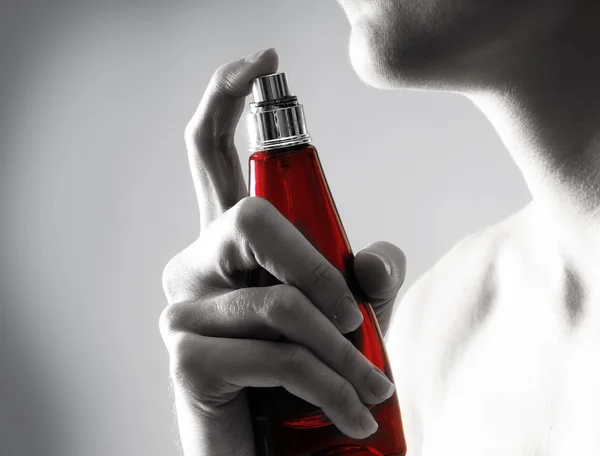 Young attractive woman with the bottle of perfume