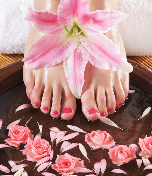 Spa background with a beautiful legs, flowers, petals and cerami