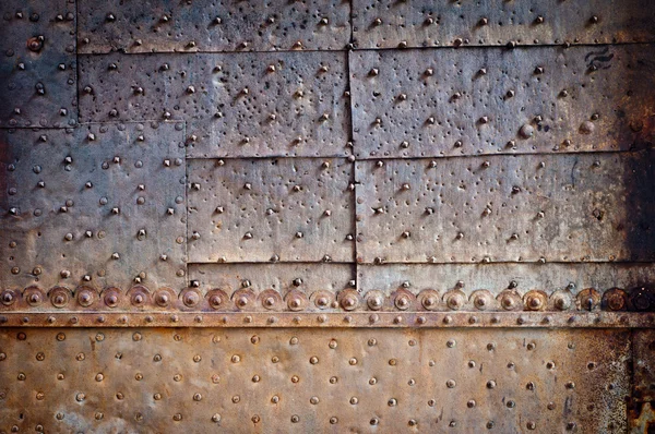 Old door rusty metal cover with rivets