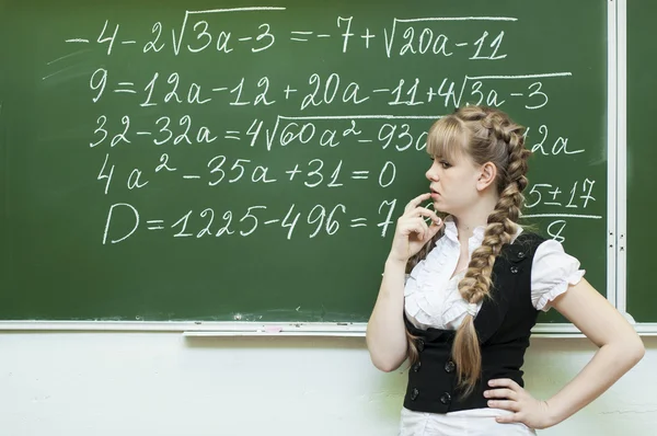Schoolgirl at the blackboard writes
