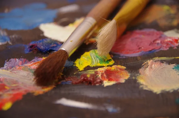 Paints and paint brushes on a palette