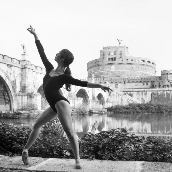 Young beautiful ballerina dancing out in Tevere riverside with castel Santangelo in the background in Rome, Italy. Black and white image. Ballerina Project.