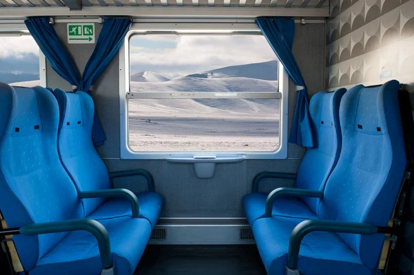 Window train with snow landscape and empty seats