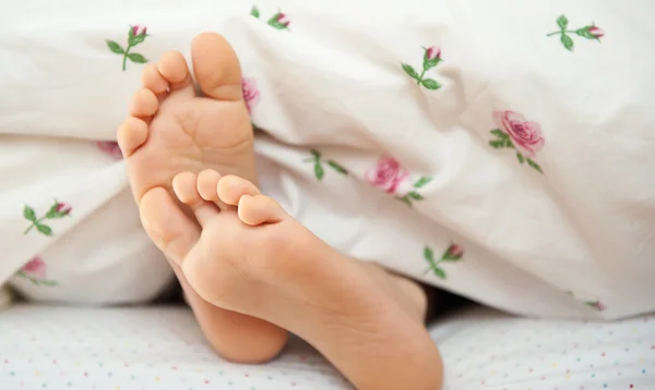 Young kid bare feet in bed