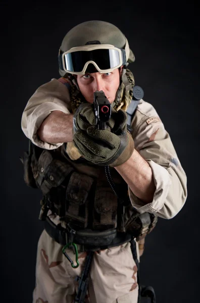 Soldier pointing gun against black background