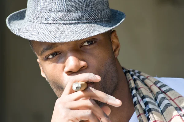 Black man smoking cigar portrait with hat